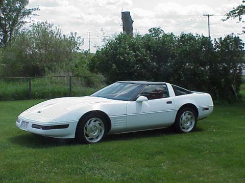 1994 Chevrolet Corvette - A white 1994 Chevrolet Corvette is shown from the front three-quarter view, parked on a grassy lawn.