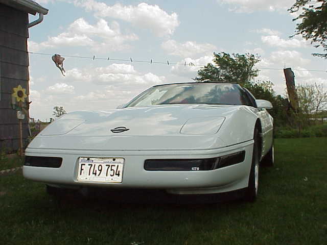 White 1994 Chevrolet Corvette with a license plate reading F 749 754 parked on grass