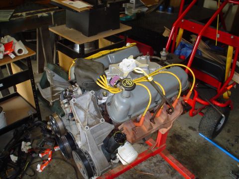 1981 Ford Bronco - An engine is mounted on a stand in a workshop, with a go-kart frame visible in the background.