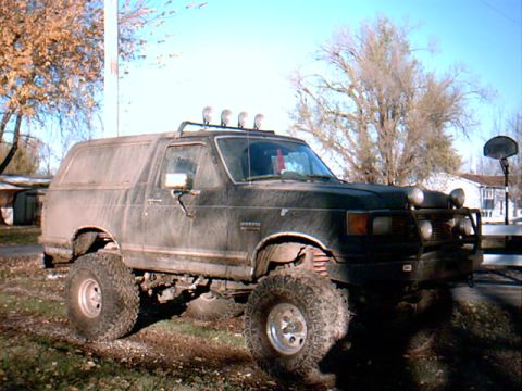 1990 Ford Bronco - This lifted 1990 Ford Bronco features large off-road tires and auxiliary lights mounted on the roof rack.
