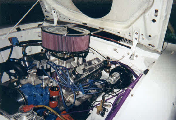 Engine bay of a 1976 Ford Mustang II with a purple air filter