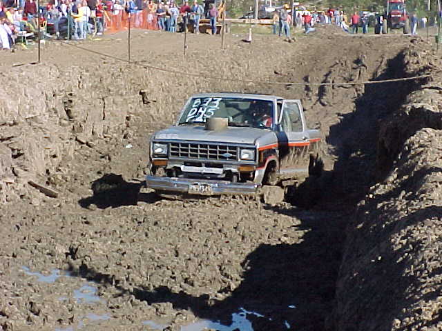 1987 Ford Ranger driving through a mud pit with spectators in the background