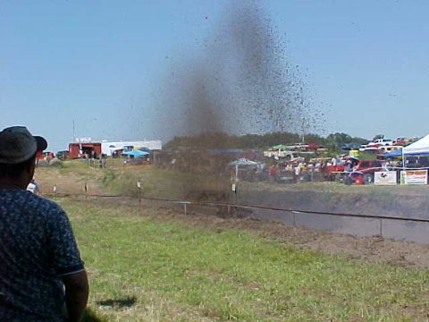1987 Ford Ranger - Spectators watch as mud is churned up at an outdoor event with multiple vehicles visible in the background.