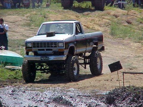 1987 Ford Ranger - A lifted 1987 Ford Ranger with a custom hood scoop navigates a muddy off-road course.