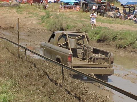 1987 Ford Ranger - A modified pickup truck navigates a muddy track during an off-road event.