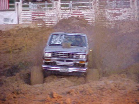1987 Ford Ranger - A 1987 Ford Ranger navigates a muddy track, kicking up dirt as it goes.