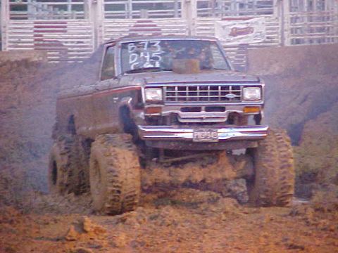 1987 Ford Ranger - Mud bogging truck, likely a 1987 Ford Ranger, driving through thick mud.