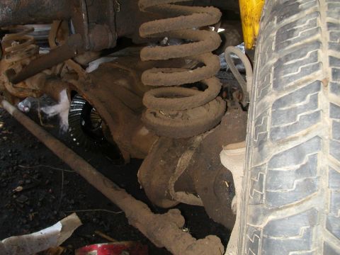 1993 Ford Bronco - Close-up view of the front axle and suspension system of a vehicle.
