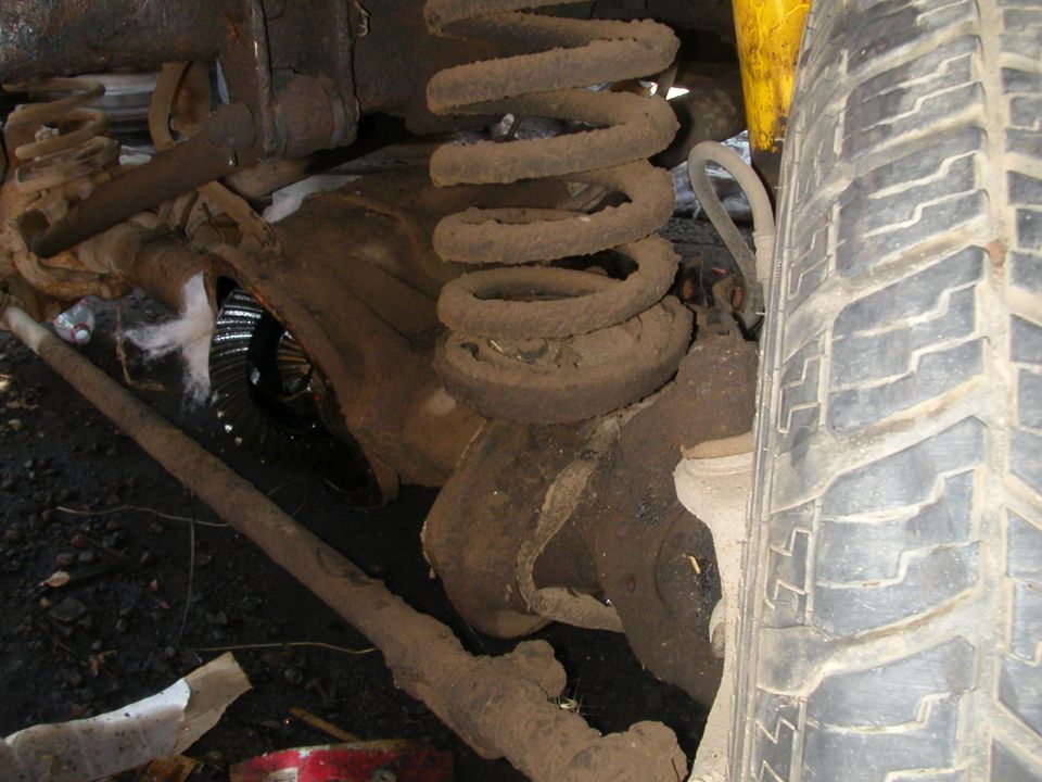 Front axle with coil spring, shock absorber, and tire visible