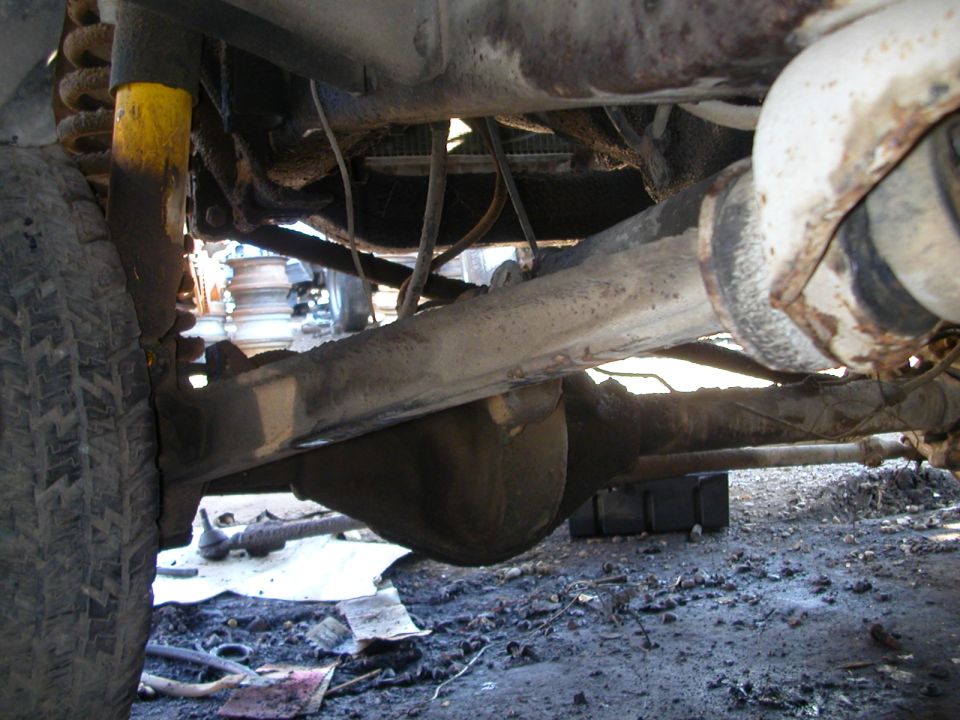 Front axle and suspension of a vehicle, showing a differential and tire