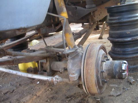 1993 Ford Bronco - Close-up view of a vehicle's front axle assembly, showing leaf springs, a shock absorber, and brake components.