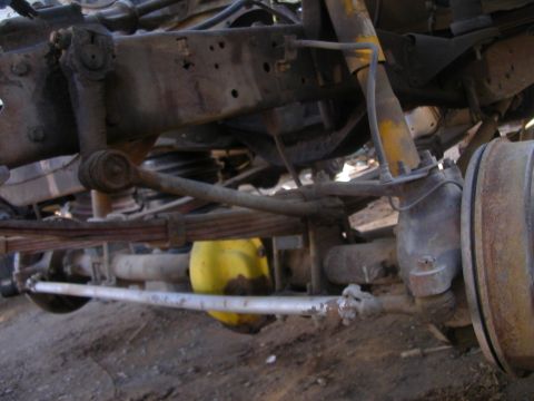 1993 Ford Bronco - Front axle and suspension parts of an older vehicle, showing leaf springs and steering components.