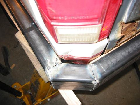 1985 Ford Bronco - Custom metal tubing is being welded to form a new rear bumper, adjacent to the vehicle's taillight.