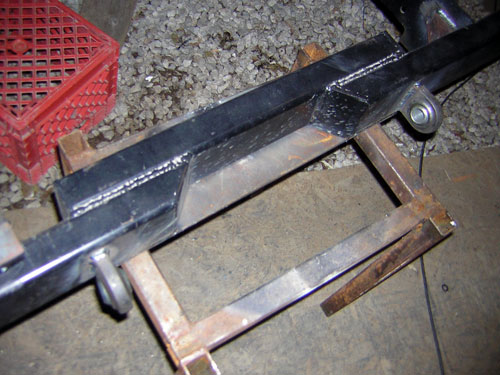 Welded steel bumper fabrication clamped in a bench vise with fresh weld beads