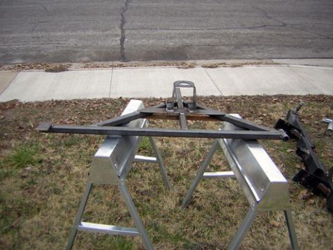 1995 Ford Bronco - A metal trailer hitch frame is shown resting on two sawhorses outdoors.