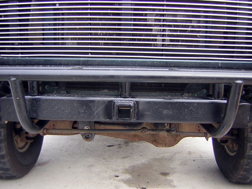 Black tubular front bumper with receiver hitch below a billet grille
