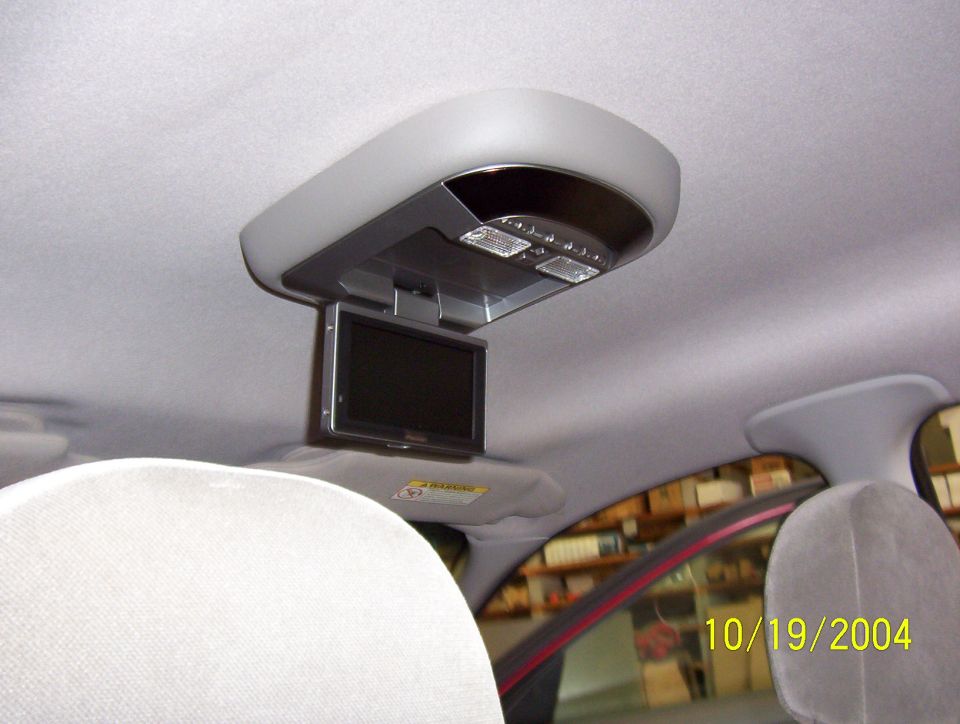 Overhead console with flip-down screen and lights inside a car interior