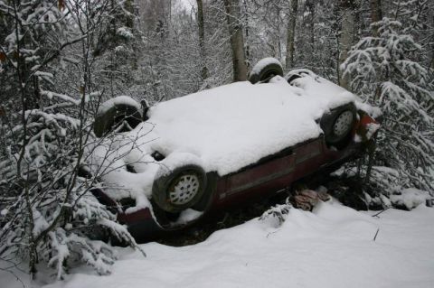 2003 Jeep TJ - Car overturned in snow-covered woods, likely after an accident.