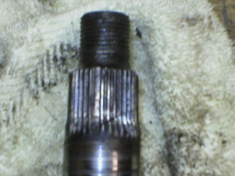 1978 Ford Bronco - A close-up view of a damaged metal shaft, showing wear on its splined section and a threaded end.