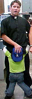 1993 Ford Bronco - Man in clerical collar holding a child wearing a blue baseball cap.