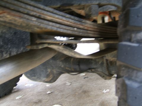 1978 Ford Bronco - Undercarriage view showing leaf springs, exhaust pipe, and tire tread.