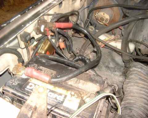 1985 Ford F-150 - Close-up view of engine bay components, including a battery and various electrical connections.