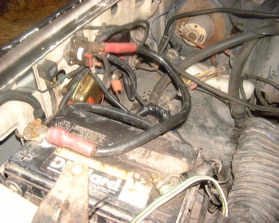 DieHard battery and cables running to a fender-mounted Ford starter solenoid in a dirty engine bay