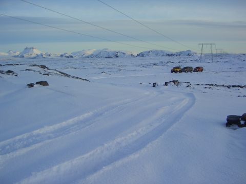 1996 Ford Bronco - Three SUVs are parked in a snowy landscape with mountains and power lines visible.