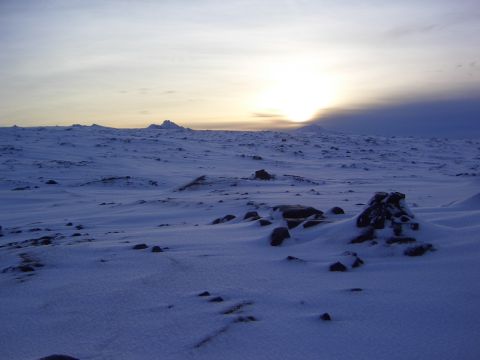 1996 Ford Bronco - A vast, snow-covered landscape stretches towards the horizon under a pale, setting sun.