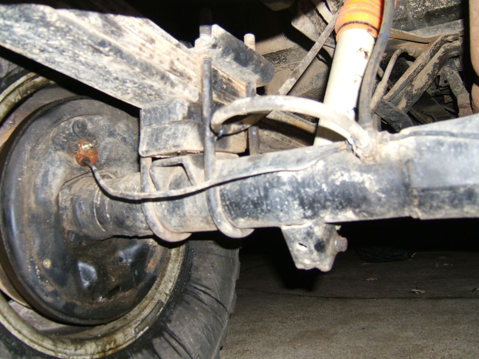 close-up of vehicle's rear axle, leaf springs, and shock absorber