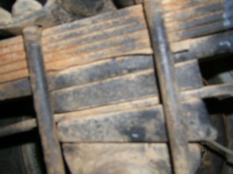 1978 Ford Bronco - Close-up view of vehicle leaf springs and U-bolts, indicating wear and tear.