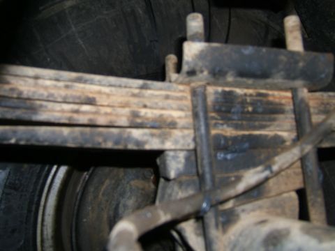 1978 Ford Bronco - Leaf spring assembly and tire detail from a vehicle's undercarriage.