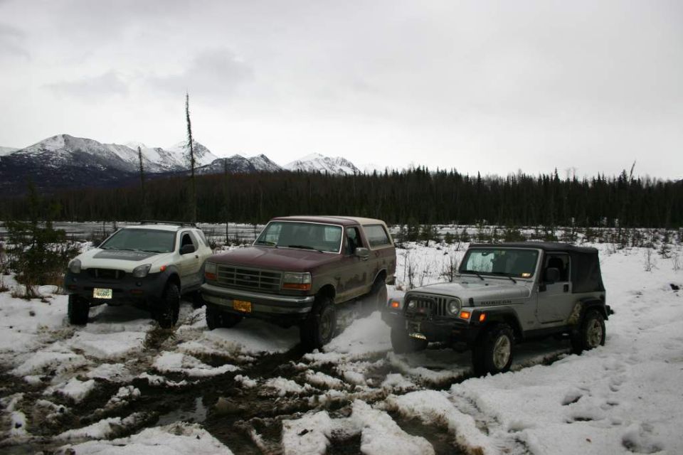 Ford Bronco, Jeep Wrangler, and Isuzu VehiCROSS parked in snow with mountains in background