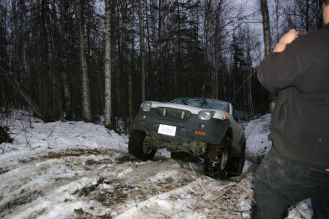 2003 Jeep TJ - SUV navigates a snowy, wooded path. The license plate is visible.
