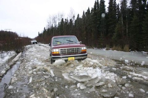 1993 Ford Bronco - A maroon Ford F-Series truck navigates a hazardous icy road with another vehicle in the distance.