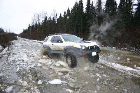 1993 Ford Bronco - SUV navigates a challenging icy road with water and debris.