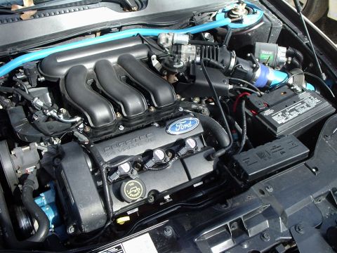 2000 Ford Taurus - The engine bay of a 2000 Ford Taurus features a Duratec 2.4L V6 engine and a blue strut bar.