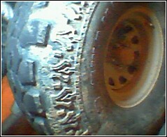 1995 Ford Bronco - A close-up view of a vehicle's tire and wheel assembly, showing tread detail and the rim.
