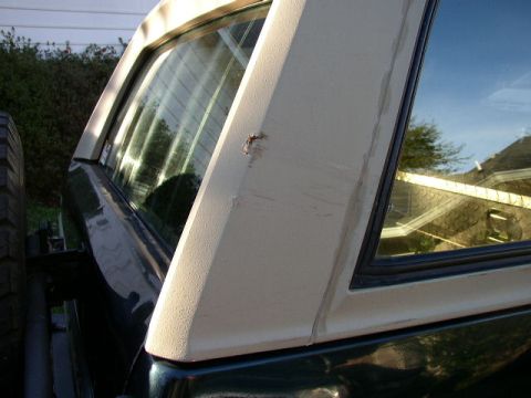 1995 Ford Bronco - A dark green 1992 Ford Bronco shows damage on its rear quarter panel and hardtop pillar.