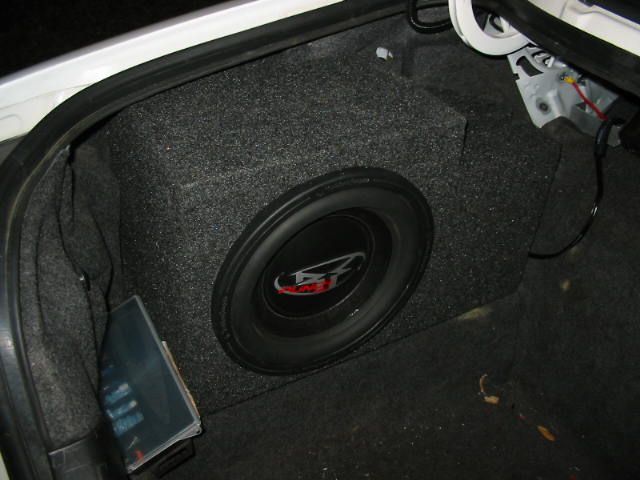 Trunk with a large subwoofer and carpeted enclosure