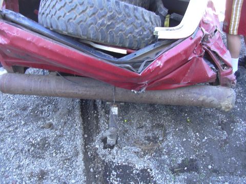 1978 Ford Bronco - The rear of a red SUV shows significant damage, with a spare tire visible inside the cargo area.
