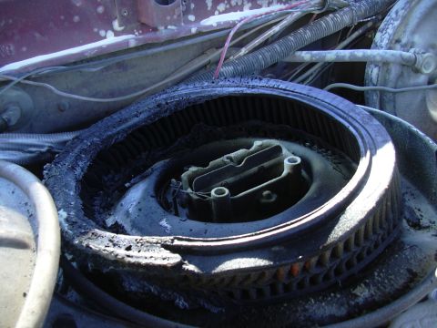 1978 Ford Bronco - Close-up of a burnt engine air cleaner assembly, showing significant damage and debris.