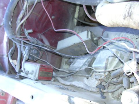 1978 Ford Bronco - A tangle of wires and components fills the engine bay, obscuring the vehicle's specific make and model.