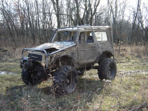 1992 Ford Bronco - This heavily modified Suzuki, covered in mud, features oversized tires and a custom roll cage, suggesting extensive off-road use.