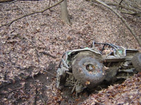 1992 Ford Bronco - This off-road buggy is stuck in the mud and tipped over on a wooded hillside.