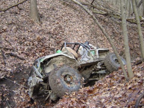1992 Ford Bronco - This heavily modified off-road vehicle appears to be stuck in a muddy ditch on a wooded slope.