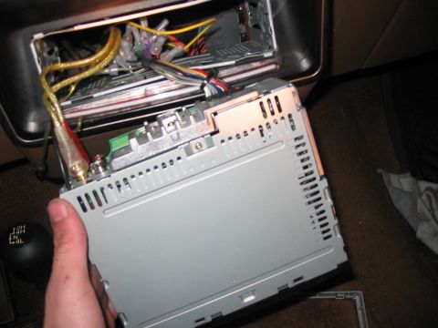 1988 Ford Bronco - Removing and installing a car stereo unit, showing wiring and connections.