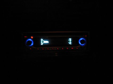 1988 Ford Bronco - The car stereo display glows blue in the dark interior of a vehicle.