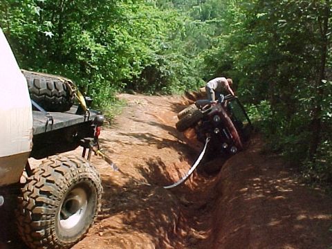 1978 Ford Bronco - Off-road recovery in progress as one vehicle is pulled from a ditch by another.