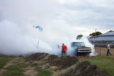 1977 Ford F-150 - A black pickup truck is seen in a cloud of smoke, possibly during an event.